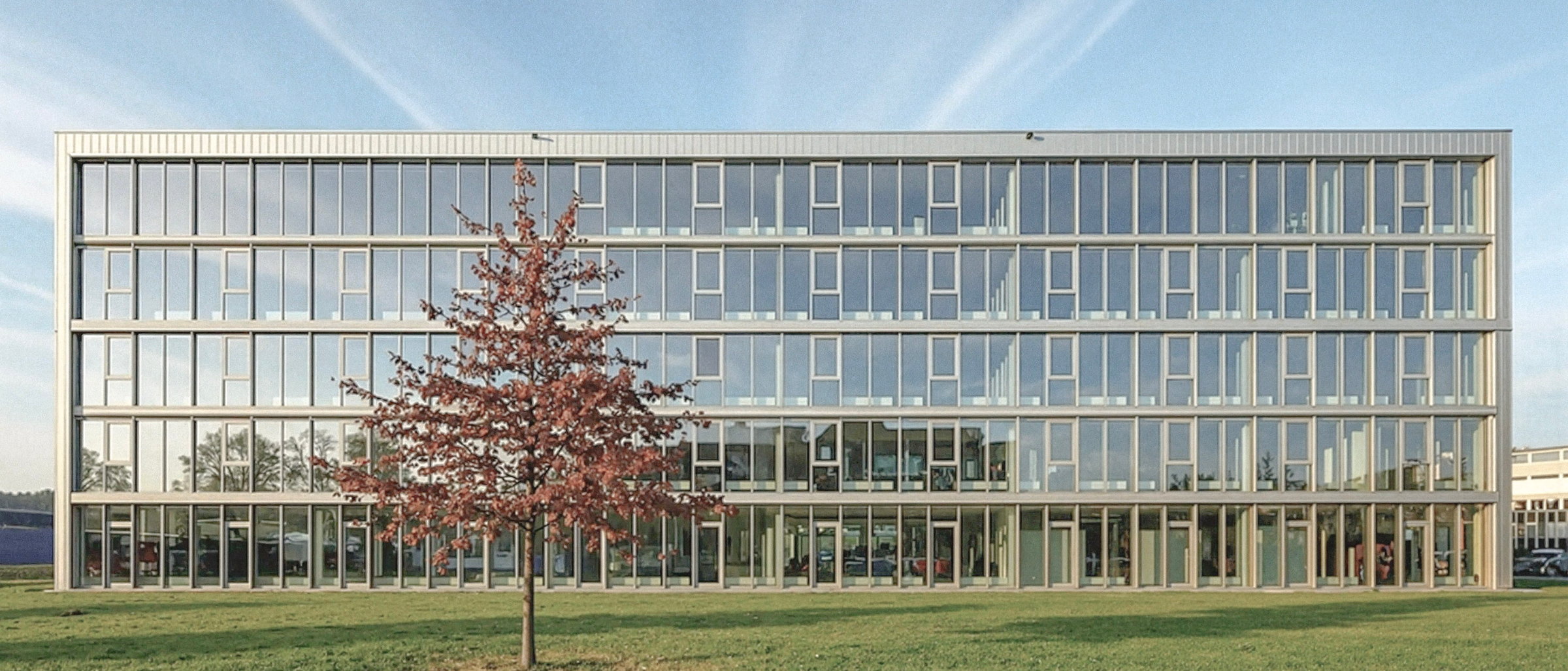 Bürogebäude KURT.SG in St. Gallen mit Glasfassade und herbstlichem Baum