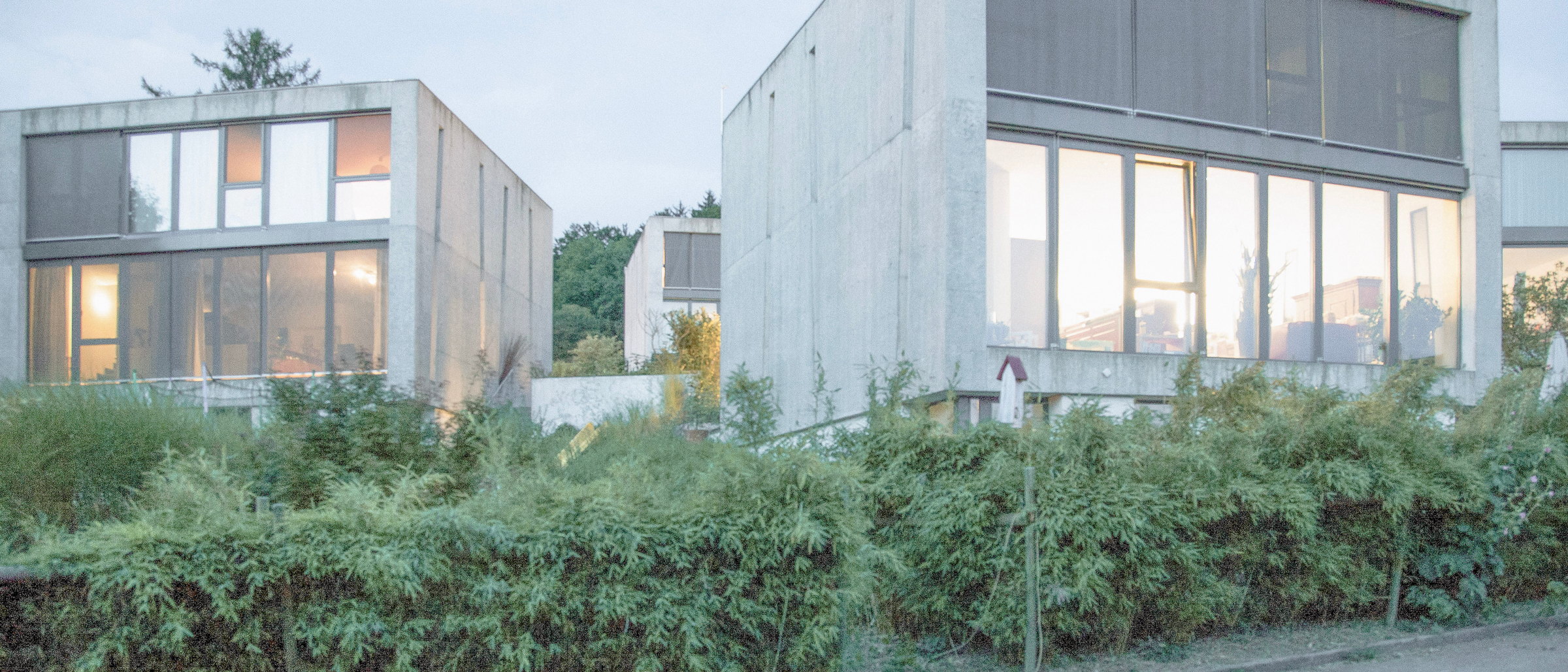 Beleuchtete Betonhäuser der Überbauung like2live in Winterthur zur blauen Stunde