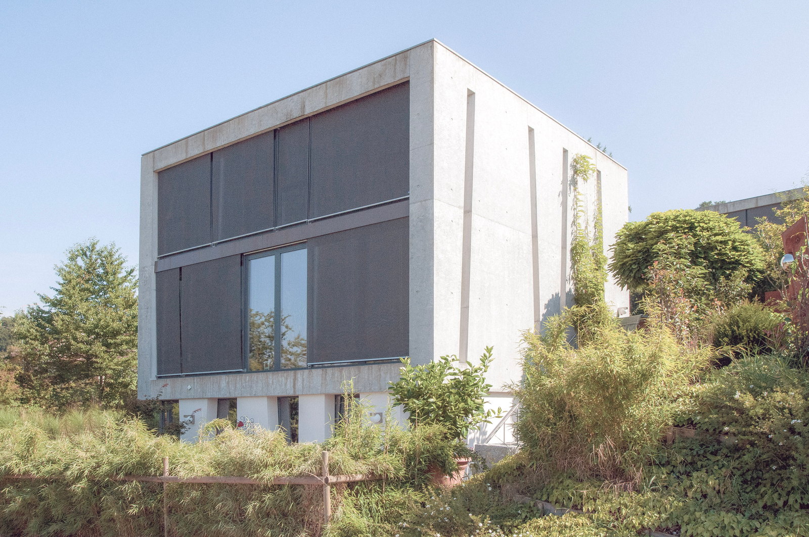 Betonhaus mit heruntergelassenen Storen in der Überbauung like2live